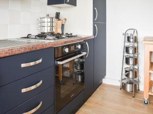 a kitchen with black cabinets and a counter top at Eastcliff Bungalow in Mundesley +5 photos