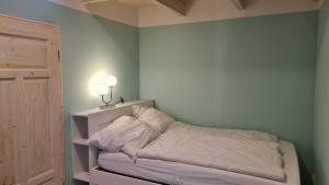 a bedroom with a bed with white sheets on it at Haus Lüchtje Jade in Sehestedt