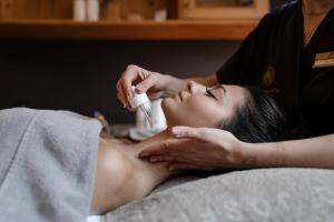 a woman getting a massage from a therapist at Tevini Dolomites Charming Hotel in Commezzadura