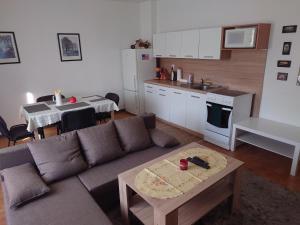 a living room with a couch and a kitchen with a table at Zukalka 2KK - 1 in Ostrava