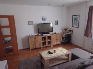 a living room with a flat screen tv on a wooden cabinet at Zukalka 2KK - 1 in Ostrava +8 photos