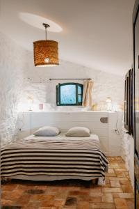 a bedroom with a bed in a room with white walls at Masia Can Pares in Sant Pere de Ribes
