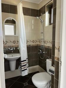 a bathroom with a toilet and a sink and a shower at kaLe in Ravda +14 photos