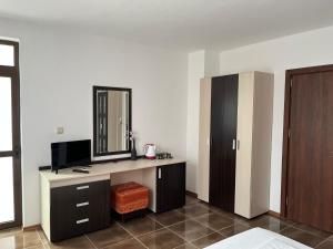 a bedroom with a dresser with a mirror and a cabinet at kaLe in Ravda