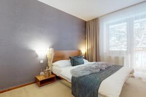 a bedroom with a large bed and a window at Apartmán Deluxe Jasná in Belá +34 photos