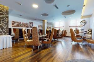 a restaurant with chairs and tables in a room at Apartmán Deluxe Jasná in Belá