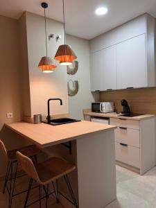 a kitchen with a kitchen island with two bar stools at Apartamentos Turísticos La Terraza* in Las Cabezas de San Juan