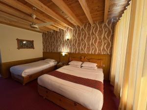 a hotel room with two beds in a room at Eagle's Nest Hotel in Karimabad Hunza