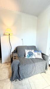a bed in a room with a lamp and pillows at Apto na Praia do Cassino in Rio Grande