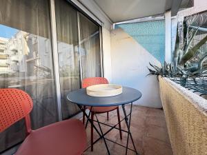 a small table and two chairs on a balcony at Sète Studio Parking Privé Loggia in Sète