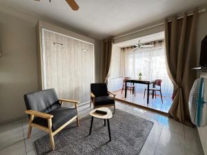a living room with two chairs and a table at Sète Studio Parking Privé Loggia in Sète