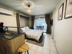a bedroom with a bed and a table and chairs at Sète Studio Parking Privé Loggia in Sète