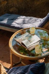 a glass table with two glasses and a book on it at Masia Can Pares in Sant Pere de Ribes
