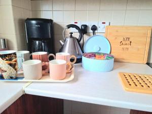 a counter top with cups and other items on it at Nice relaxing apartment in Mandria, in Mandria