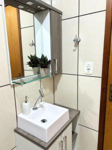 a bathroom with a sink and a mirror at Apto na Praia do Cassino in Rio Grande +13 photos