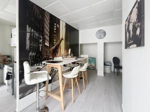 a kitchen with a table and white chairs in a room at Le Antoine in Compiègne
