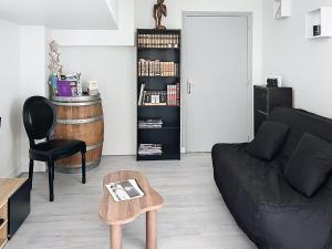 a living room with a black couch and a table at Le Antoine in Compiègne