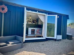 a blue shed with a door open to a kitchen at Cabin on the Moors in Llansannan