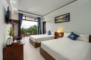 a hotel room with two beds and a balcony at Muoi Villa in Hiếu Nhơn