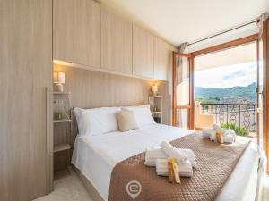 a bedroom with a large bed and a large window at Estay - Maria's Wonderful Retreat in Villasimius