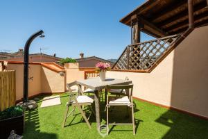 a patio with a table and chairs on the grass at Estay - Maria's Wonderful Retreat in Villasimius