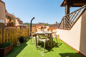 a small backyard with a table and chairs on grass at Estay - Maria's Wonderful Retreat in Villasimius