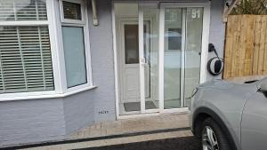 a house with a white door and a car parked outside at The White House in Moston