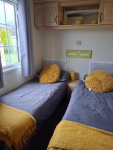 two beds in a small room with a window at St Nicholas Number 5 in Turnberry