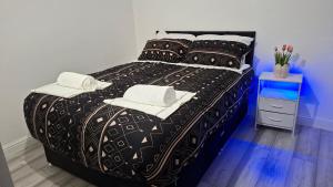 a black bed with white towels on top of it at The White House in Moston