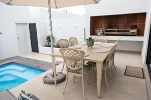 a dining room with a table and chairs and an umbrella at Oceana View at Oceans 3 Selfcatering Holiday Home in Rand Rifles