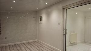 an empty room with a sliding glass door at The White House in Moston +58 photos