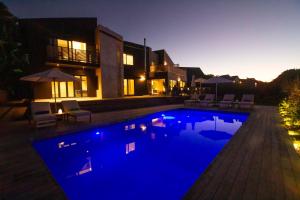 a swimming pool with blue lighting in front of a house at IL Gattopardo in Wilderness +36 photos