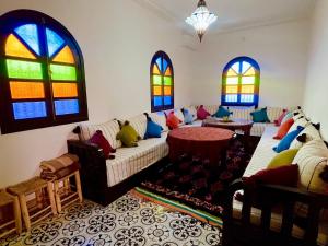 a living room with a couch and stained glass windows at Palais Aya in Oulad Akkou