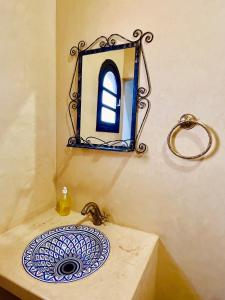 a bathroom with a sink and a mirror on the wall at Palais Aya in Oulad Akkou +29 photos
