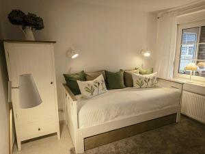 a bedroom with a bed with green and white pillows at Ferienhaus Sommerwiese - ABC327 in Klein Warin