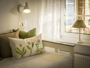 a bedroom with a window with a pillow and a lamp at Ferienhaus Sommerwiese - ABC327 in Klein Warin +15 photos