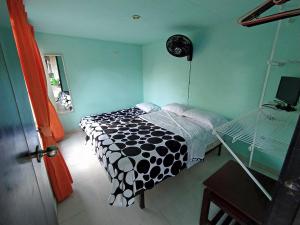 a bedroom with a bed with a black and white comforter at Casa Campestre Villa Alejandra in La Tebaida