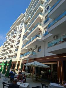 people sitting at tables outside of a large building at Kevin&Elisa Your home! in Lezhë