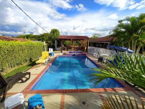 a swimming pool in a yard with a house at Casa Campestre Villa Alejandra in La Tebaida