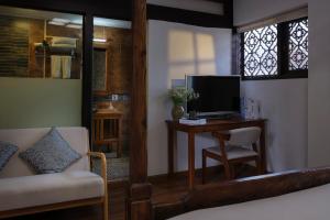 a bedroom with a bed and a desk with a television at 十二星客栈 in Lijiang