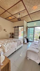 a bedroom with a large bed and a large window at สะปันไลฟ์ in Ban Huai Ti +12 photos