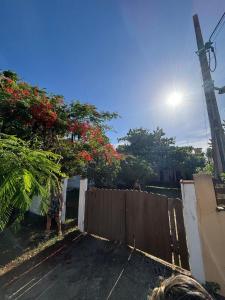a driveway with a fence with flowers on it at Cantinho do tricolor in Saquarema