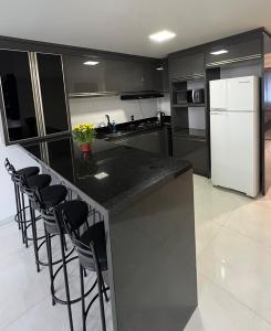 a kitchen with a black counter and a white refrigerator at Apartamento em Pomerode - 205 in Pomerode