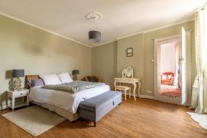 a bedroom with a bed and a table and a window at La Maison Haute in La Fosse-de-Tigné