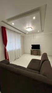 a living room with a couch and a flat screen tv at Apartamento em Pomerode - 205 in Pomerode