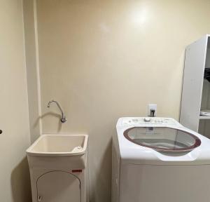 a bathroom with a sink and a washing machine at Apartamento em Pomerode - 205 in Pomerode