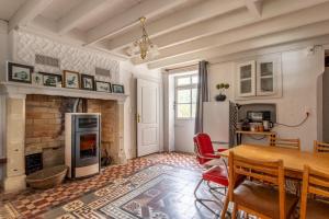 a living room with a table and a fireplace at La Maison Haute in La Fosse-de-Tigné