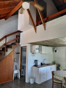 a kitchen with white cabinets and a wooden ceiling at El Encuentro in Piriápolis