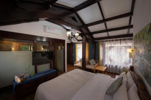 a bedroom with a large bed and a living room at 十二星客栈 in Lijiang