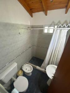 a bathroom with a toilet and a sink at Balcón del Cerro Cabañas in La Falda +14 photos